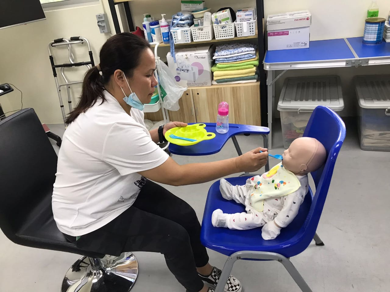 Culinary trained Filipino maid demonstrating toddler solid food weaning and safe high chair spoon feeding protocols