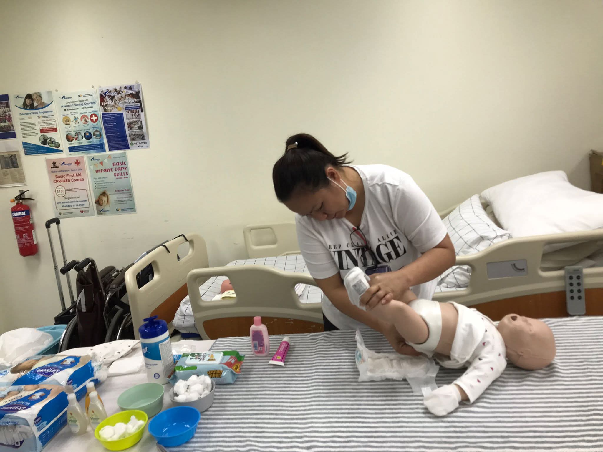 Elite Filipino nanny practicing sanitary infant diaper changes and skin cleanliness application in Kuala Lumpur
