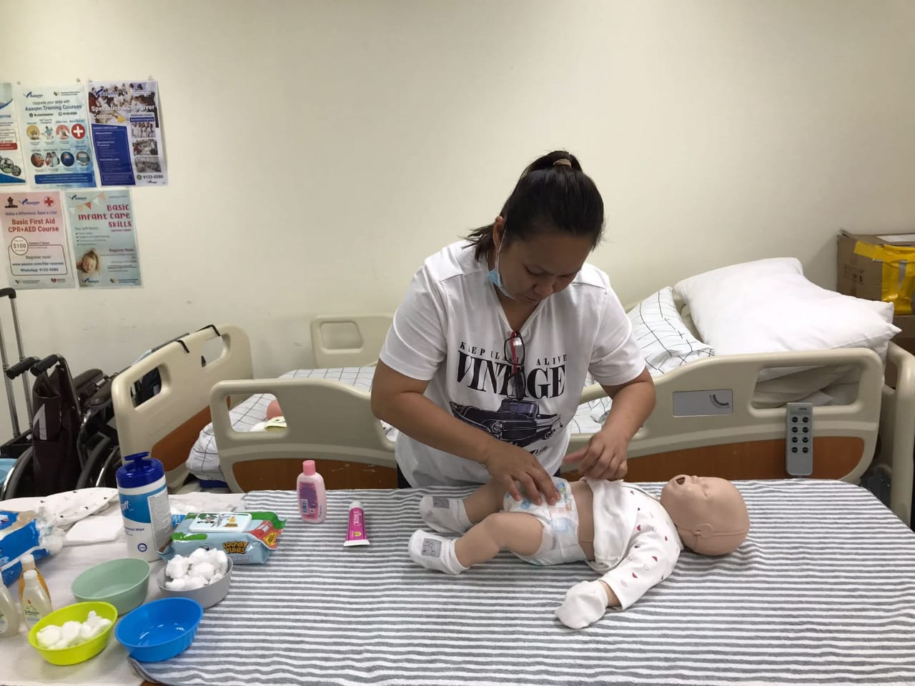 Certified Filipino nanny practicing newborn diapering and clinical childcare techniques in Malaysia