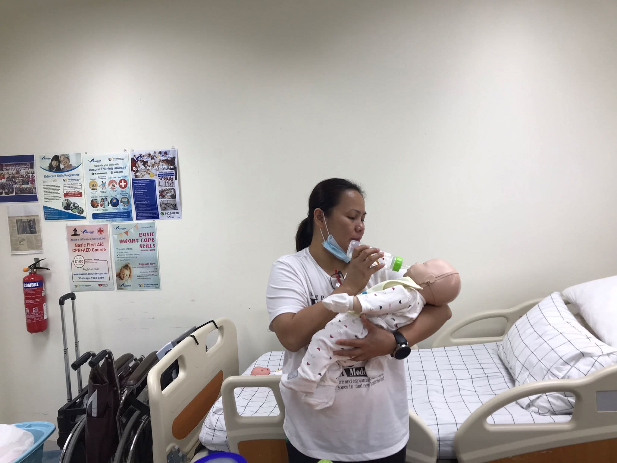 Professional Filipino nanny demonstrating standing cradle-hold bottle feeding postures to prevent choking and colic